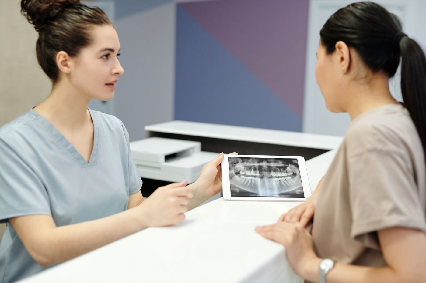 Dentista explicando uma radiografia panorâmica durante a consulta